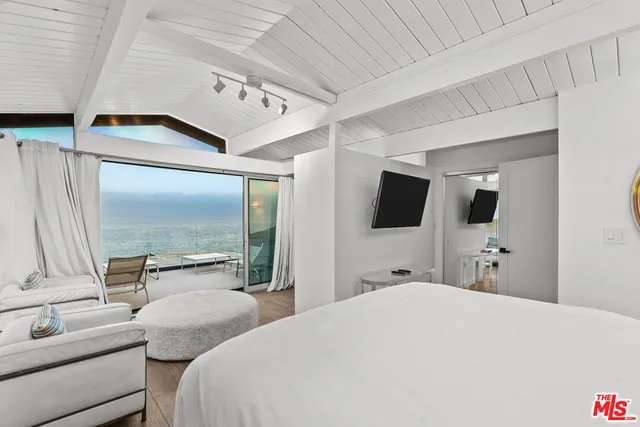 a bedroom with furniture and a large window