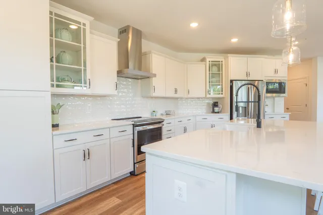 a kitchen with granite countertop white cabinets and white appliances