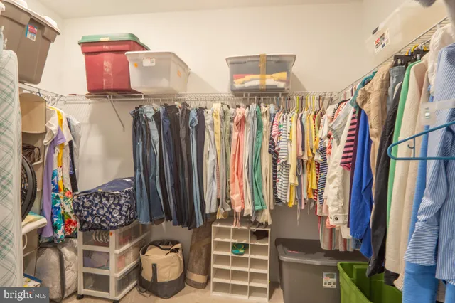 a view of walk in closet with clothes and shoes
