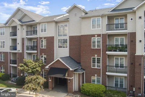 a view of a house with wooden deck and furniture