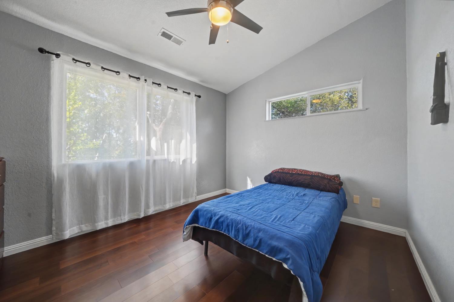 12900 New York Ranch Road Jackson, CA 95642 - Photo 19 of 31 a bedroom with a bed and a chandelier