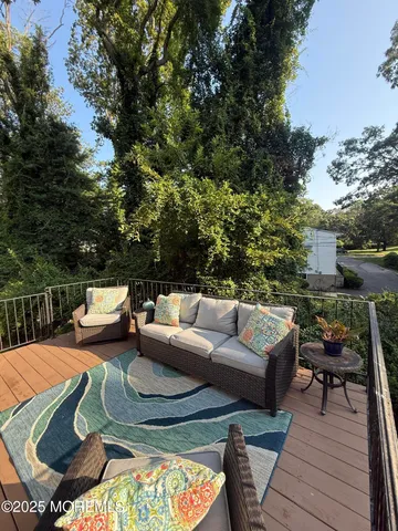 a view of a patio with couches table and chairs with wooden floor and fence