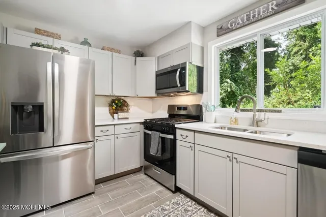 a kitchen with a refrigerator sink and cabinets