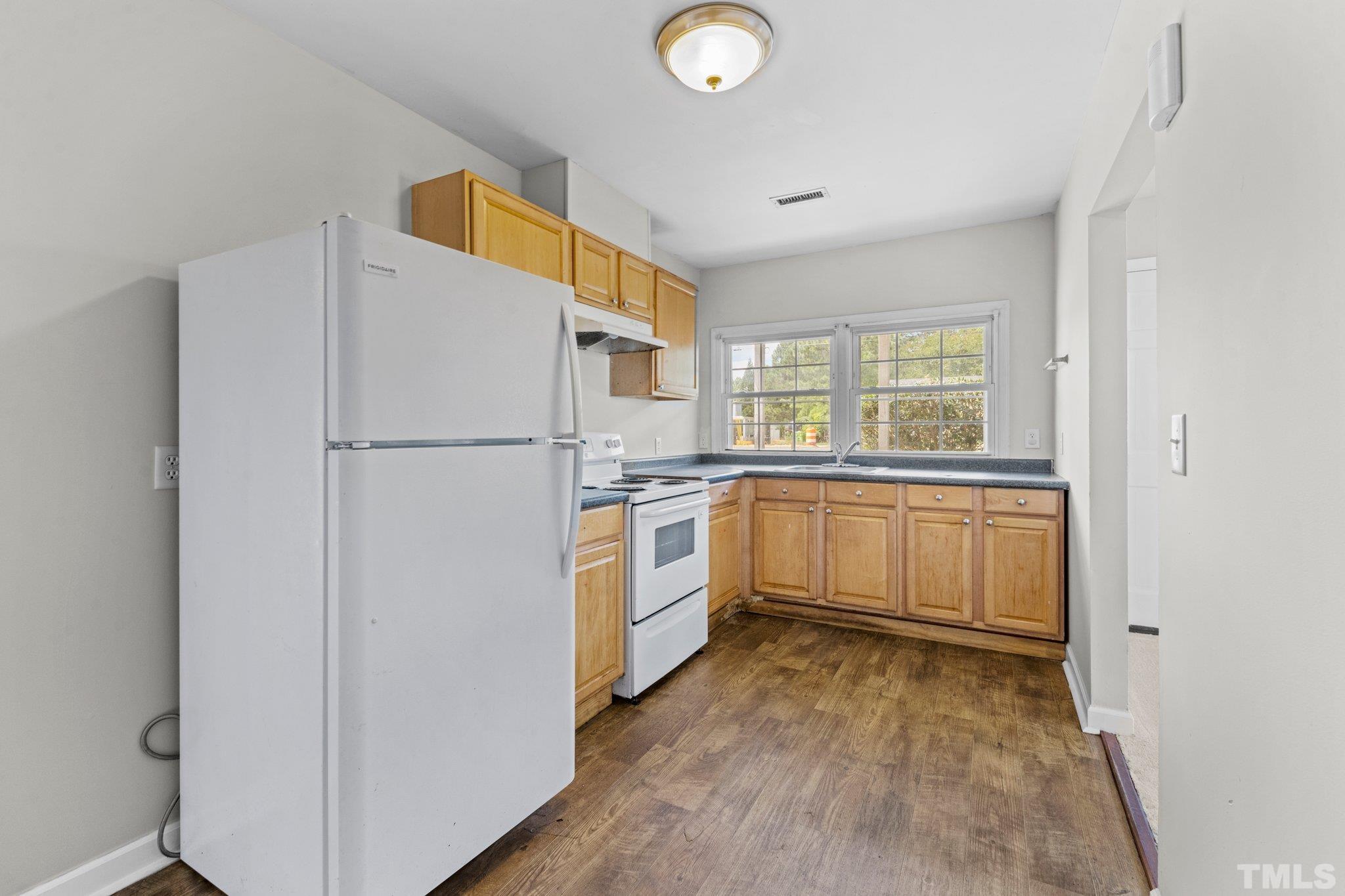 405 Jones Franklin Road Raleigh, NC 27606 - Photo 11 of 41 a kitchen with white cabinets and white appliances