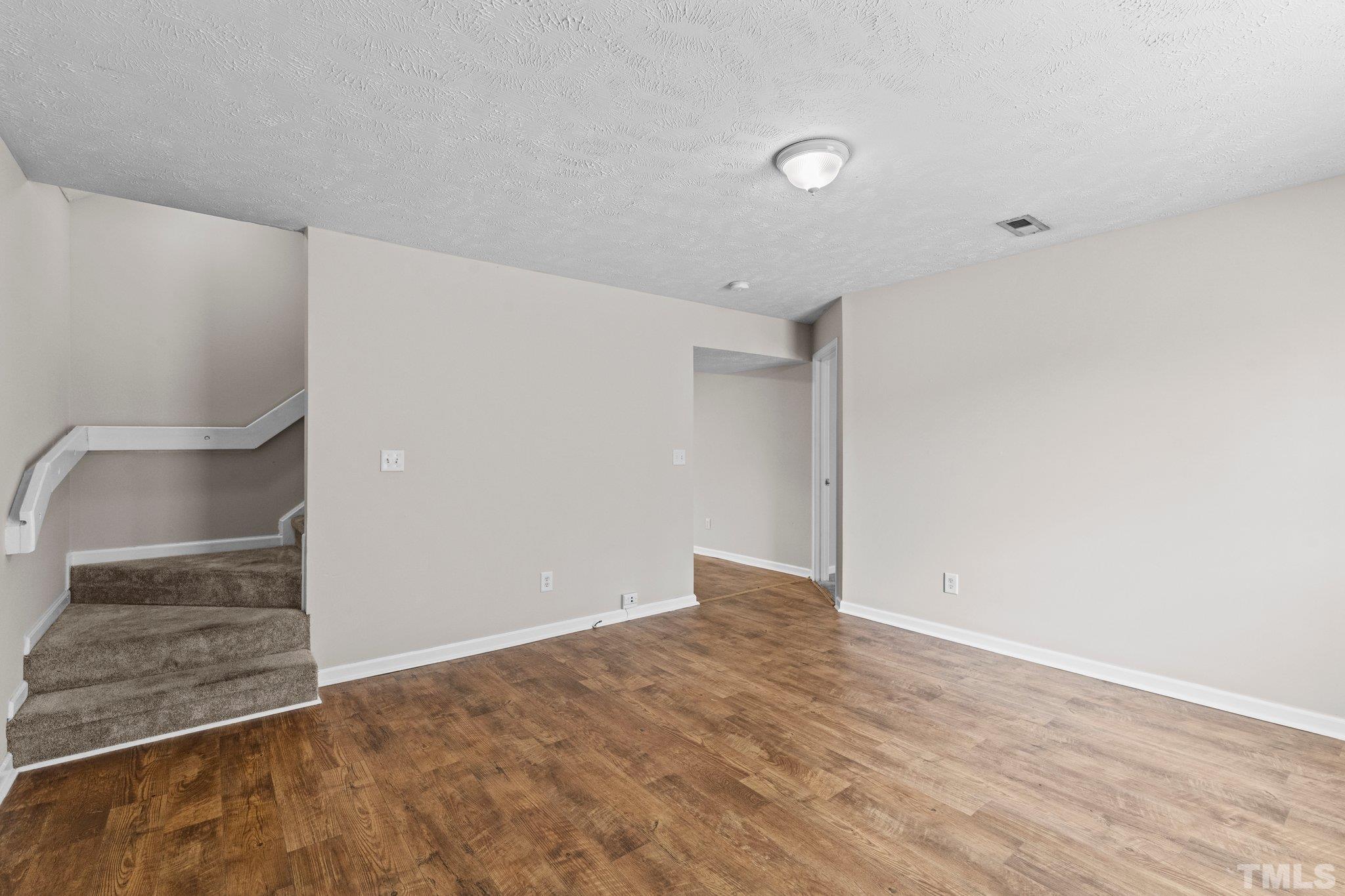 405 Jones Franklin Road Raleigh, NC 27606 - Photo 21 of 41 a view of an empty room with wooden floor and a sink