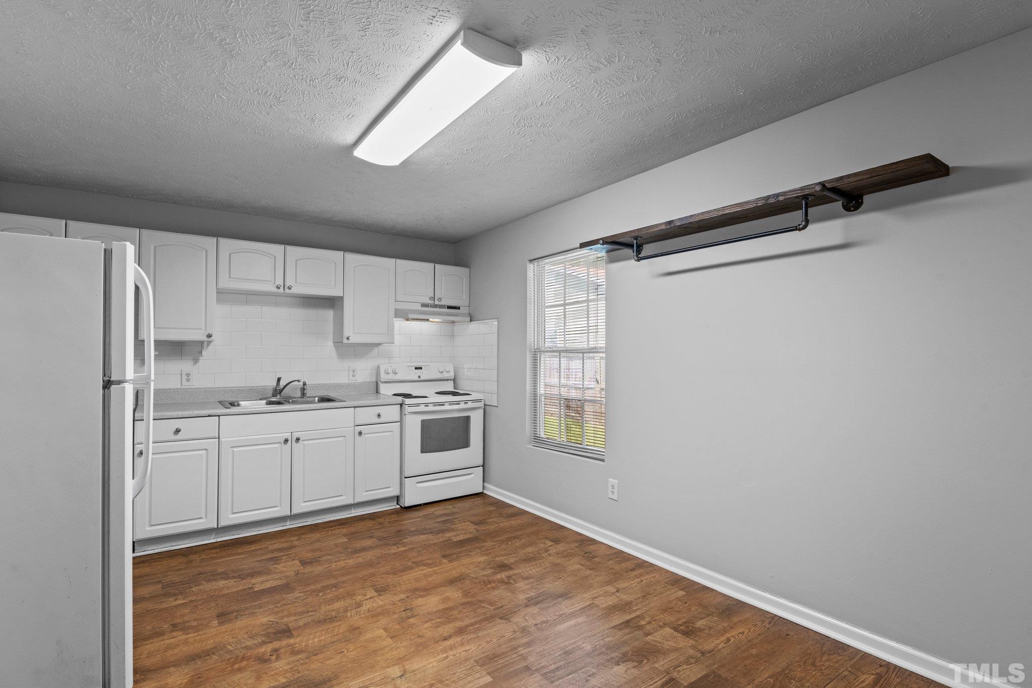 405 Jones Franklin Road Raleigh, NC 27606 - Photo 27 of 41 a kitchen with white cabinets and appliances