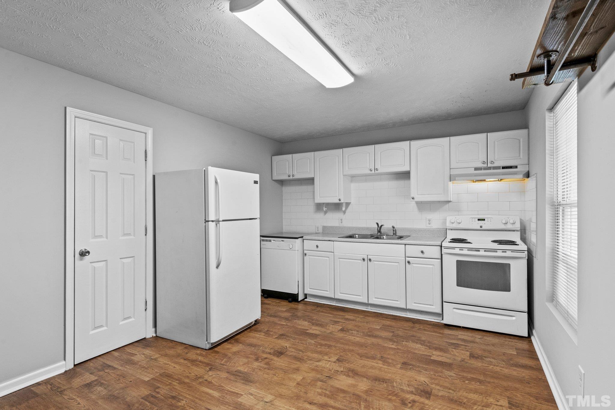 405 Jones Franklin Road Raleigh, NC 27606 - Photo 28 of 41 a kitchen with granite countertop cabinets and white appliances