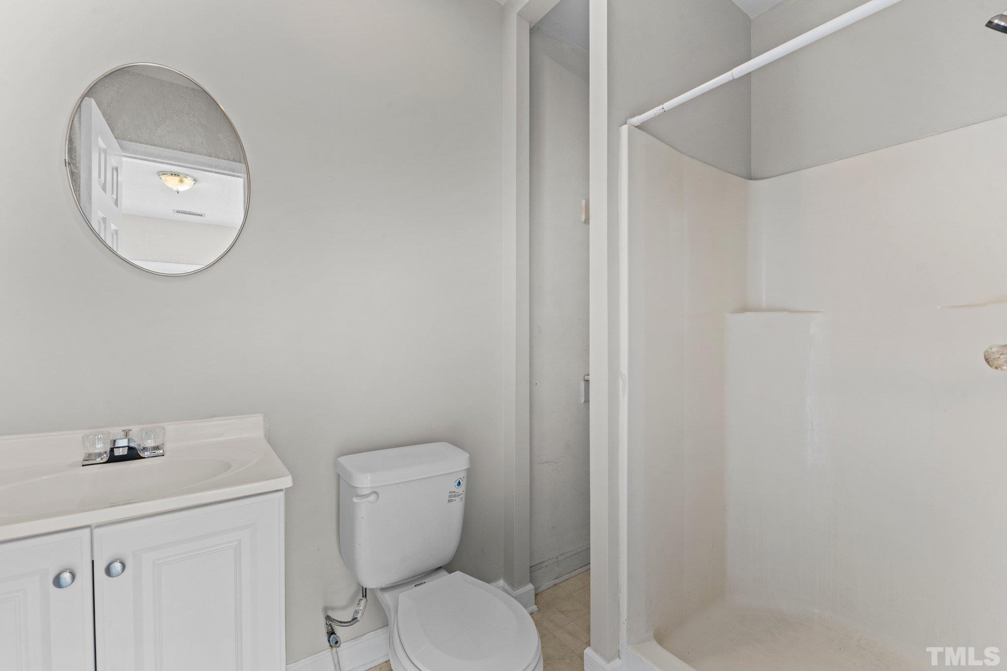 405 Jones Franklin Road Raleigh, NC 27606 - Photo 10 of 41 a bathroom with a toilet a sink and a mirror