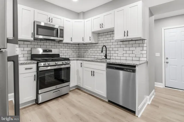 a kitchen with stainless steel appliances a stove sink and microwave