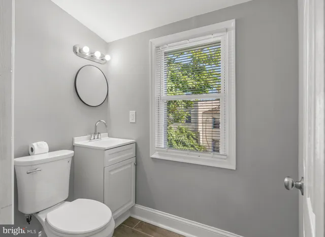 a bathroom with a toilet a sink and a mirror