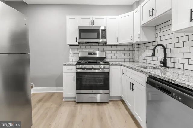 a kitchen with cabinets stainless steel appliances and a sink