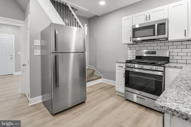 a kitchen with granite countertop wooden cabinets and stainless steel appliances