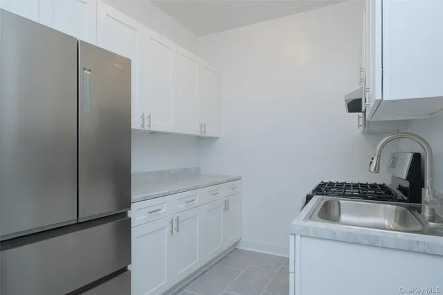 a kitchen with white cabinets and white appliances