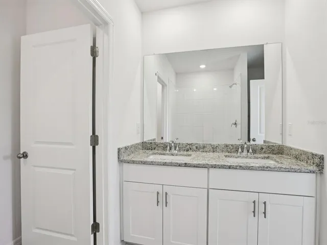a bathroom with a granite countertop sink and a mirror