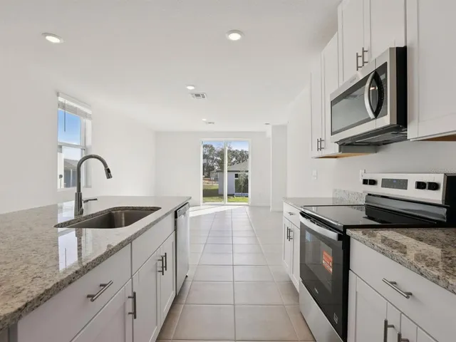 a kitchen with granite countertop a sink and cabinets