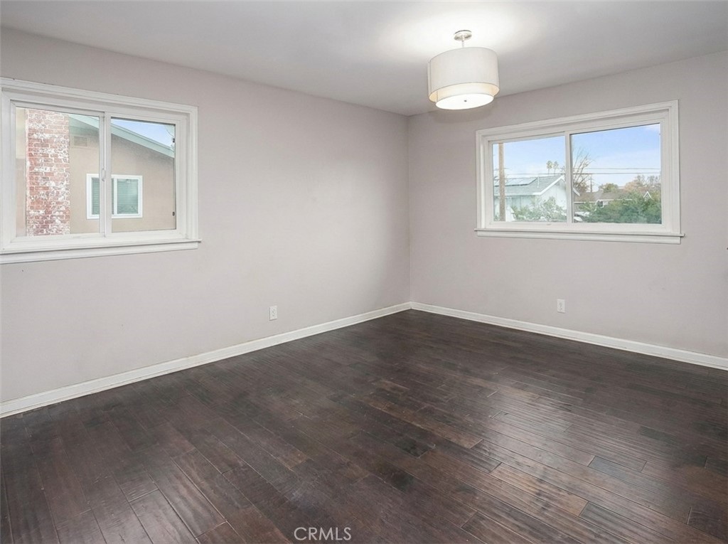 7722 Faust Avenue West Hills, CA 91304 - Photo 12 of 21 The primary suite is awash in natural light and offers sparkling windows, a modern light fixture, dual mirrored-door closets, and wood laminate floors.