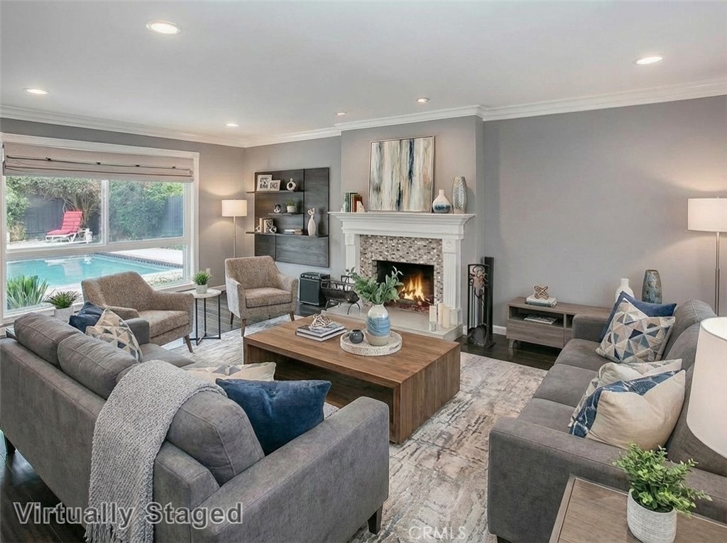 7722 Faust Avenue West Hills, CA 91304 - Photo 3 of 21 The spacious family room is filled with natural light and showcases a two-tone designer paint palette, refined crown molding, a large bay window, a custom tiled wood burning fireplace with white surround, and attractive wood laminate flooring. Virtually staged/enhanced photo