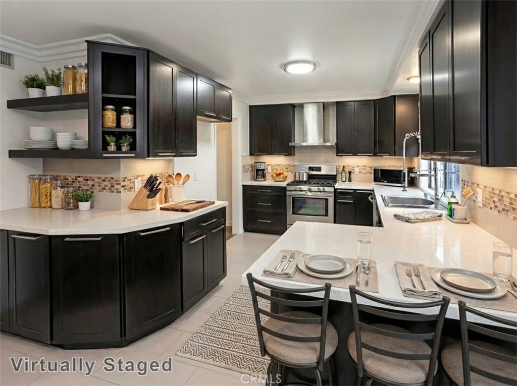 7722 Faust Avenue West Hills, CA 91304 - Photo 5 of 21 The kitchen will delight any home chef with its sunlit window, rich wood-grained cabinetry extending to the ceiling, generous counter space, custom tiled full backsplash, stainless steel basin with pull-down faucet, and stainless steel appliances including a Frigidaire® self-cleaning 5-burner gas range with Arietta® ventilation hood and Frigidaire® dishwasher, along with a convenient breakfast bar, and coffee bar; plus, a convenient breakfast area. Virtually staged/enhanced photo