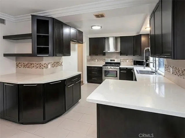a large kitchen with stainless steel appliances a large counter top