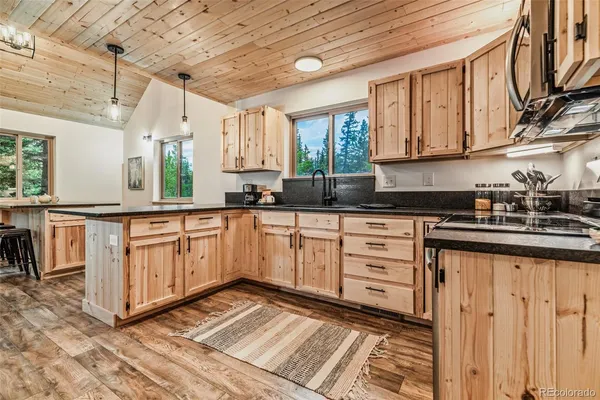 a kitchen with granite countertop a stove sink and cabinets