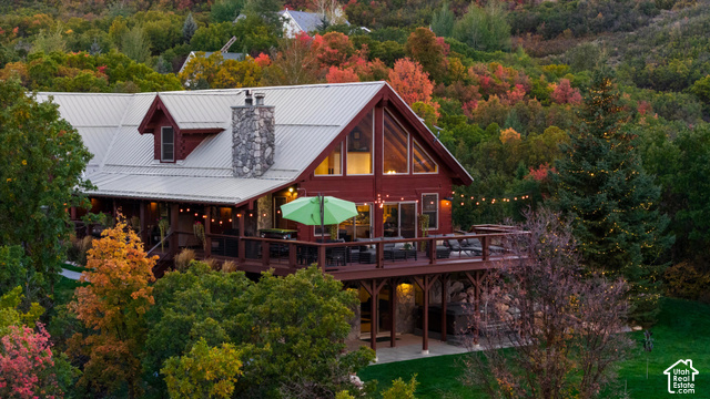 5878 Snowbasin Road Huntsville, UT 84317 - Photo 84 of 90 Red-sided home with a metal roof, prominent stone chimney, and a multi-level deck