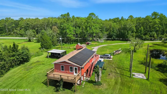 a view of a house with pool and a yard