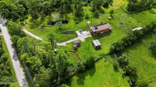 an aerial view of residential houses with outdoor space and trees all around