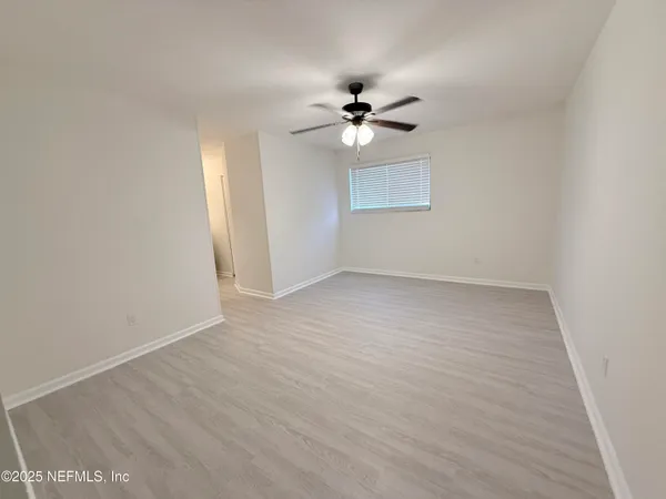 a view of empty room with wooden floor