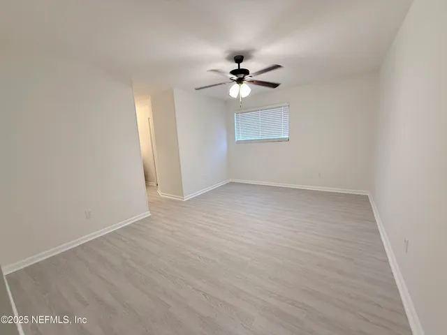 a view of empty room with wooden floor