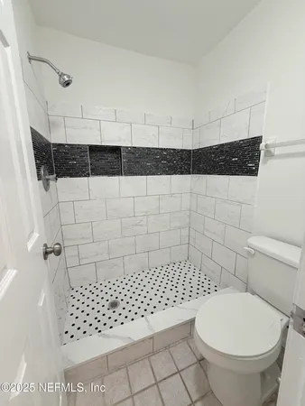 a bathroom with a toilet a window and shower