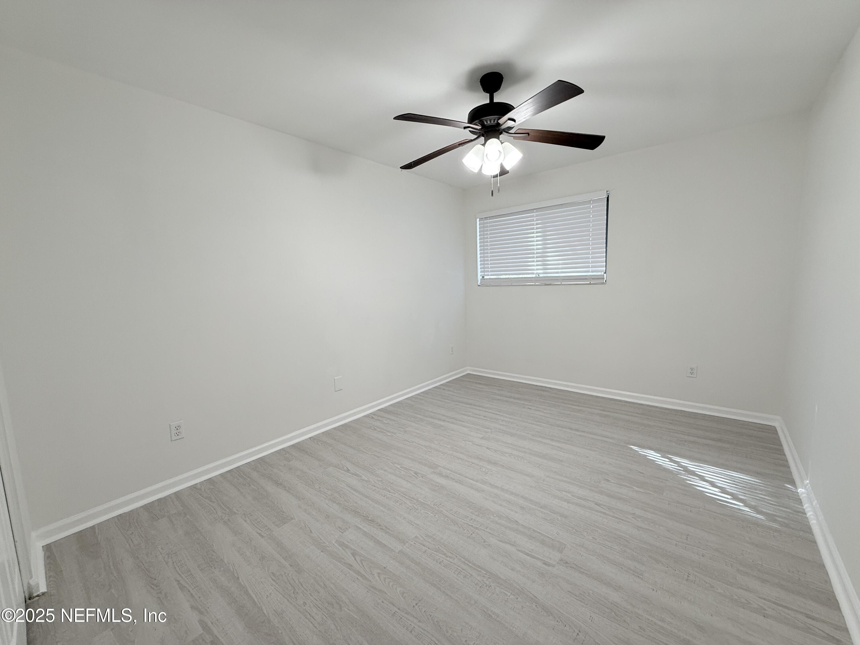 3801 Crown Point Road, Unit 2061 Jacksonville, FL 32257 - Photo 14 of 20 an empty room with wooden floor fan and windows