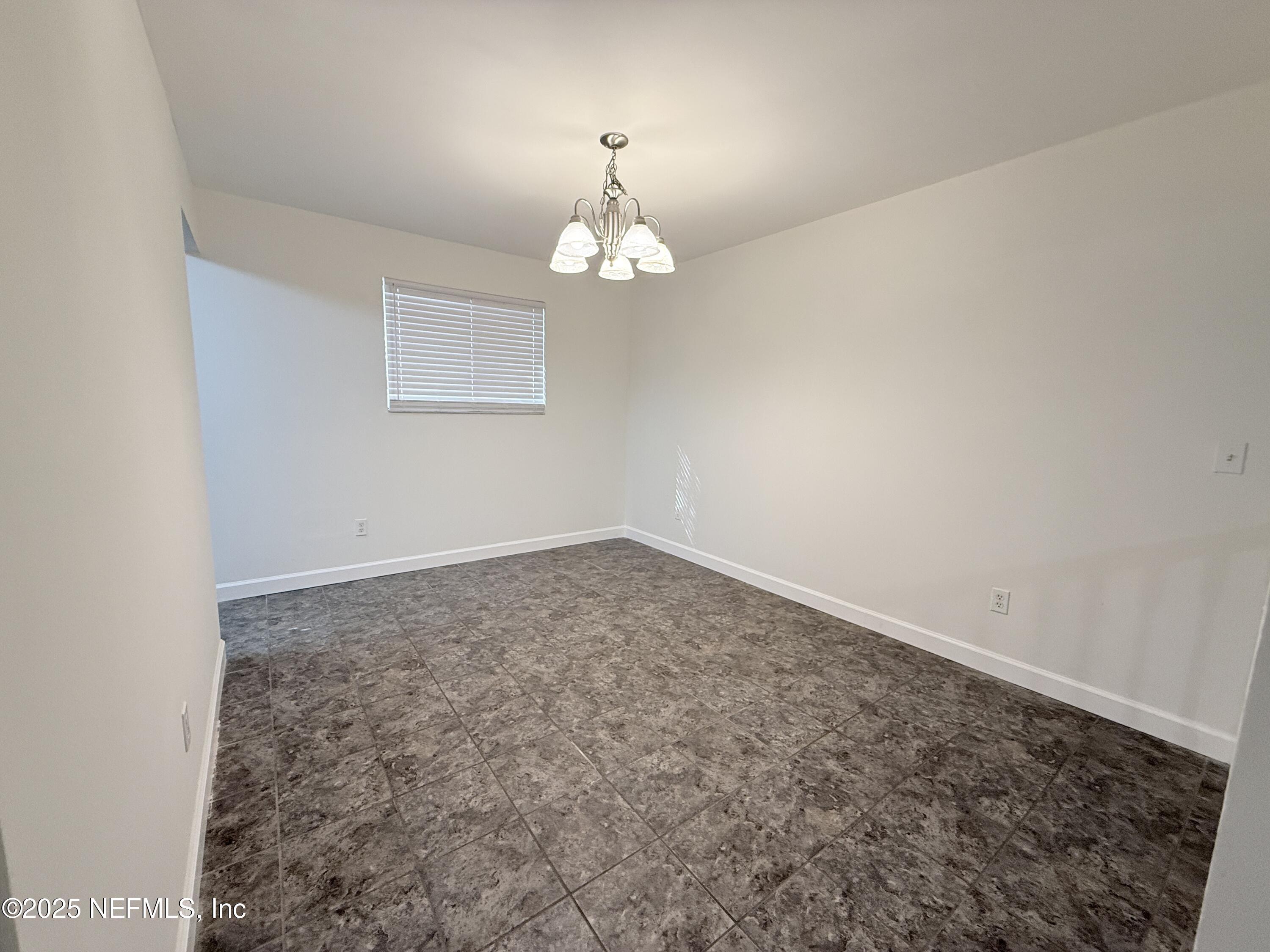 3801 Crown Point Road, Unit 2061 Jacksonville, FL 32257 - Photo 7 of 20 an empty room with a chandelier fan and windows