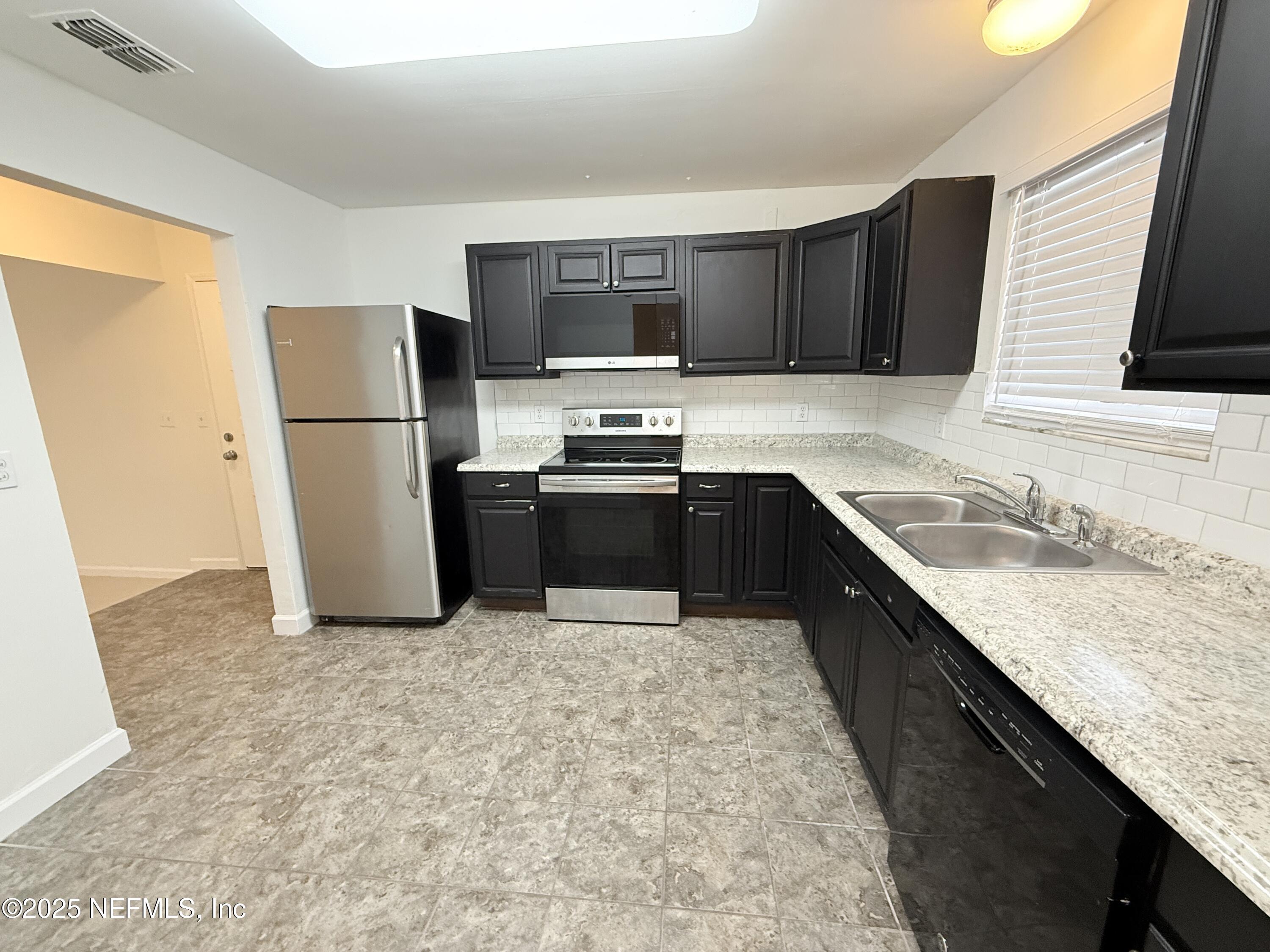 3801 Crown Point Road, Unit 2061 Jacksonville, FL 32257 - Photo 8 of 20 a kitchen with stainless steel appliances granite countertop a sink stove and refrigerator