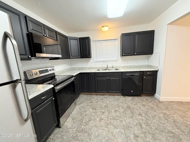 a kitchen with stainless steel appliances a sink stove and refrigerator