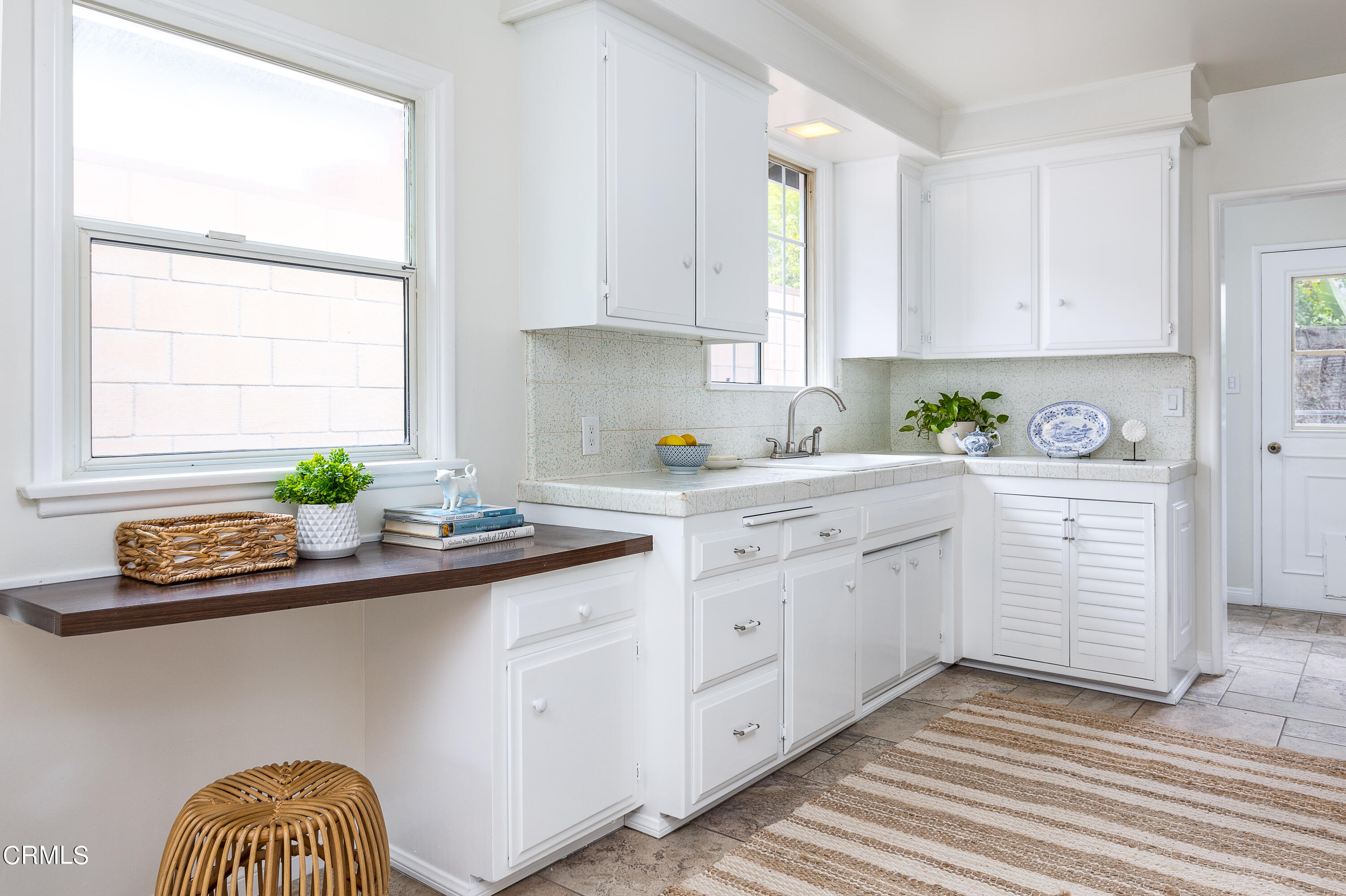 636 Birmingham Road Burbank, CA 91504 - Photo 13 of 25 a kitchen with white cabinets a sink a window and appliances