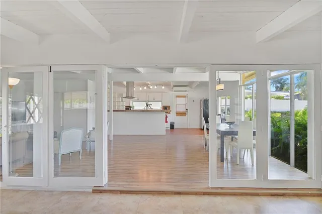 a view of a living room and kitchen view with wooden floor