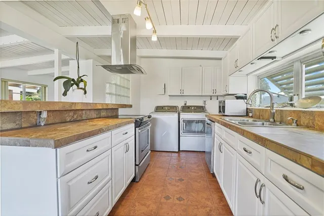 a kitchen with cabinets appliances a sink and a window