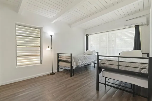 a bedroom with furniture wooden floor and a window