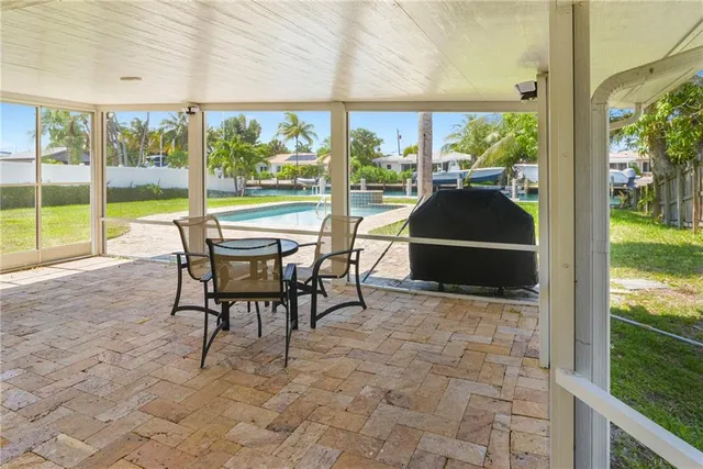a view of a patio with table and chairs and floor to ceiling window