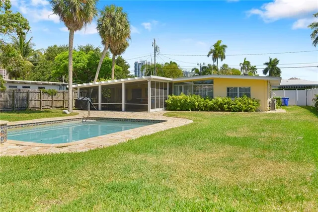 a view of a house with a backyard patio and swimming pool
