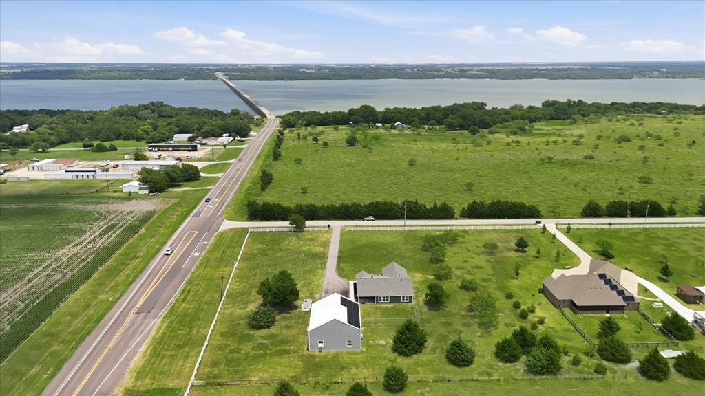 110 Highview Road Ennis, TX 75119 - Photo 37 of 40 Expansive property with a large body of water in the background, featuring multiple buildings, a paved road, and a bridge