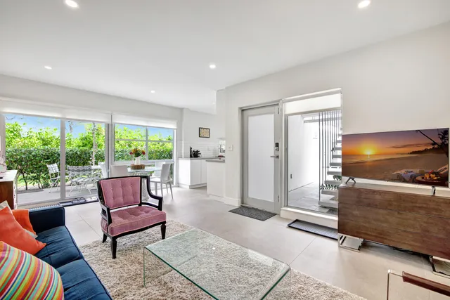 a view of a dining room with furniture a rug and a large window