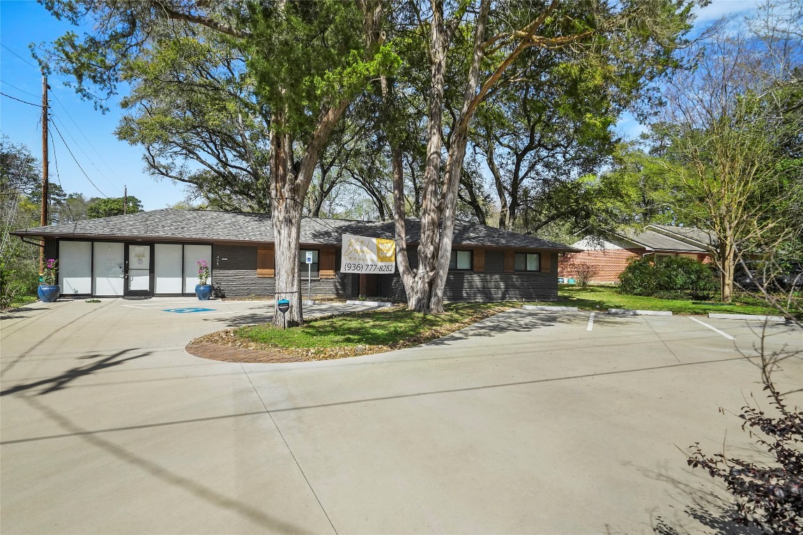 408 Wilson Road Conroe, TX 77301 - Photo 1 of 32 a front view of a house with a garden and trees