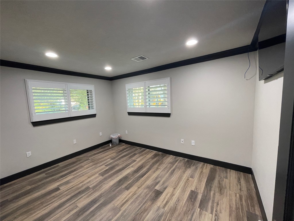 408 Wilson Road Conroe, TX 77301 - Photo 19 of 32 a view of an empty room with wooden floor and a window
