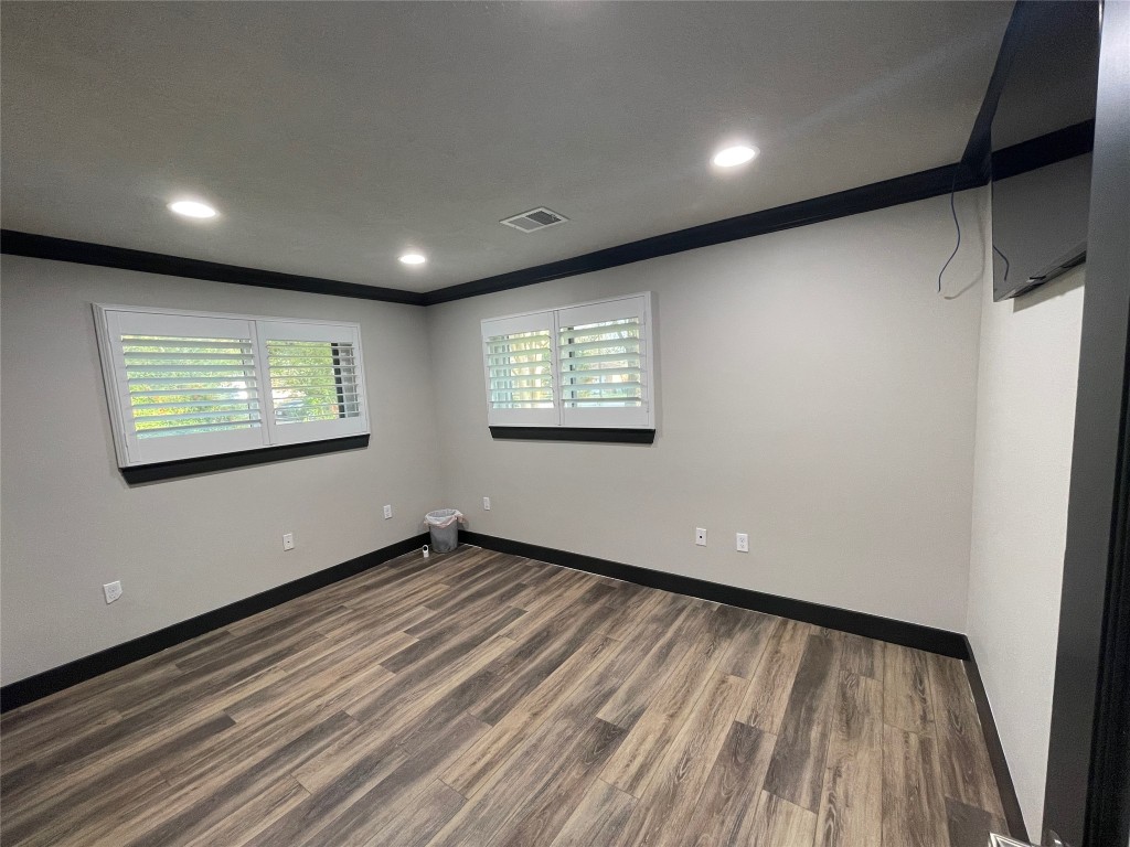 408 Wilson Road Conroe, TX 77301 - Photo 20 of 32 a view of an empty room with wooden floor and a window