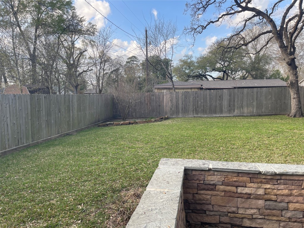 408 Wilson Road Conroe, TX 77301 - Photo 24 of 32 a view of a backyard with wooden fence