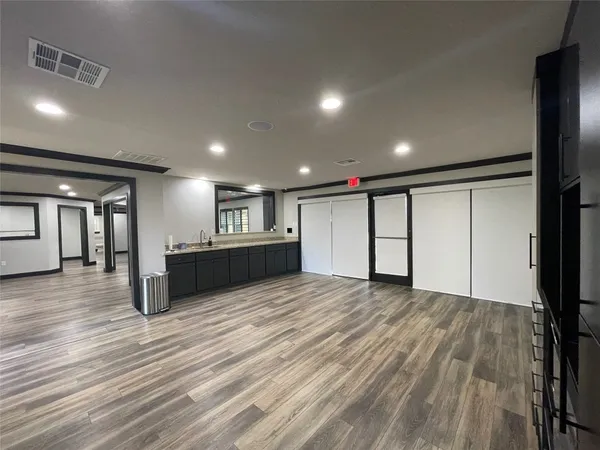 a view of an empty room with wooden floor