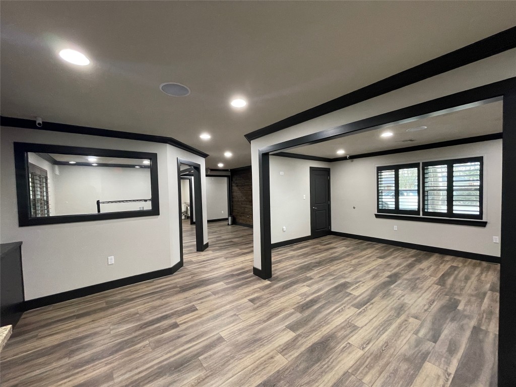 408 Wilson Road Conroe, TX 77301 - Photo 9 of 32 a view of an empty room with wooden floor and windows