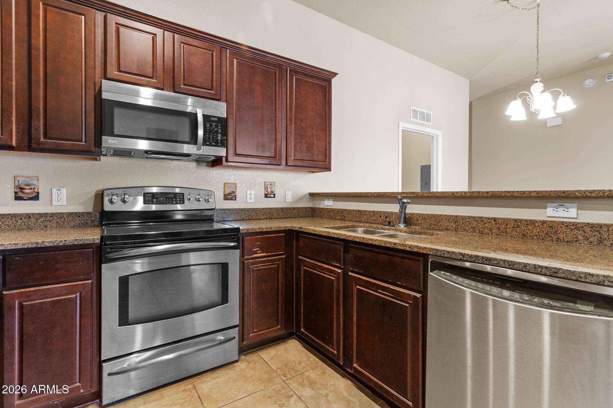 17150 North 23rd Street, Unit 243 Phoenix, AZ 85022 - Photo 17 of 24 a kitchen with stainless steel appliances granite countertop a stove microwave and sink