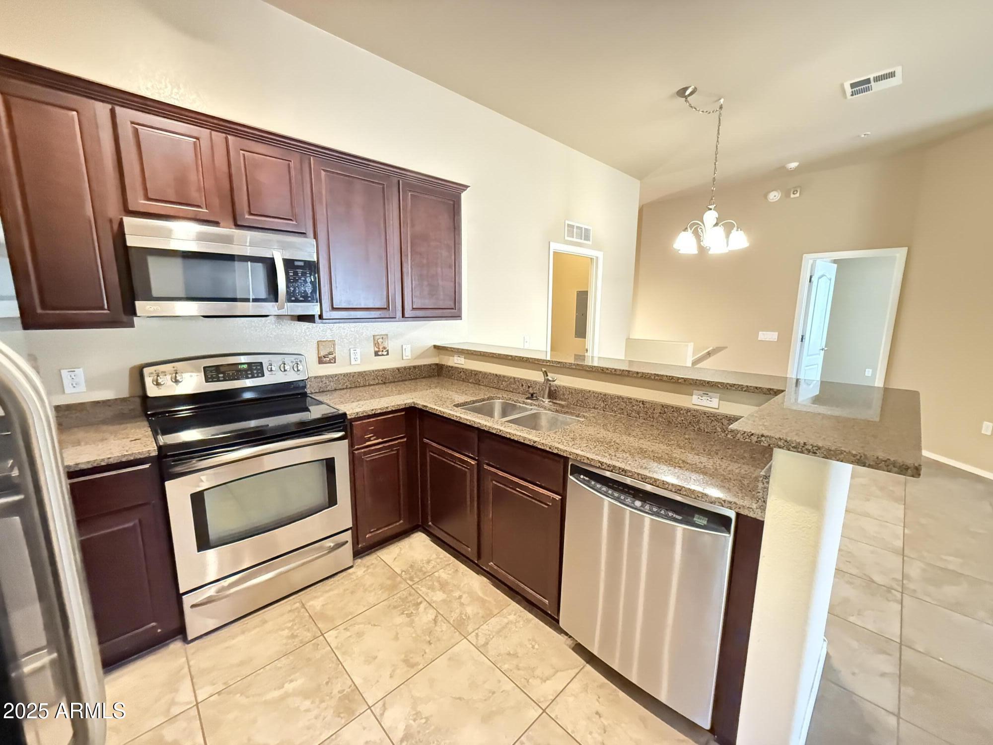 17150 North 23rd Street, Unit 243 Phoenix, AZ 85022 - Photo 7 of 36 a kitchen with granite countertop a sink and steel appliances